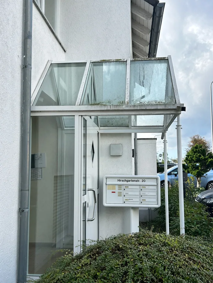 Gepflegter Hauseingang mit Glasvordach aus einem Birnbaum-Einsatz